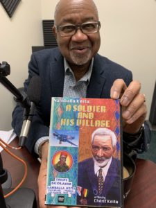 Cherif Keita in the Afripod studio with his book, A Soldier and His Village