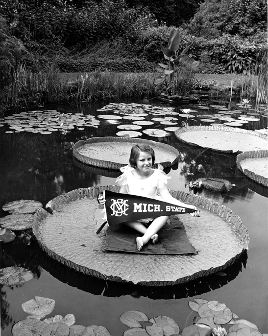 Girl sits on Lily Pad in Beal Gardens, 1938