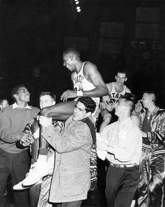 A group carries basketball players on shoulders, 1957
