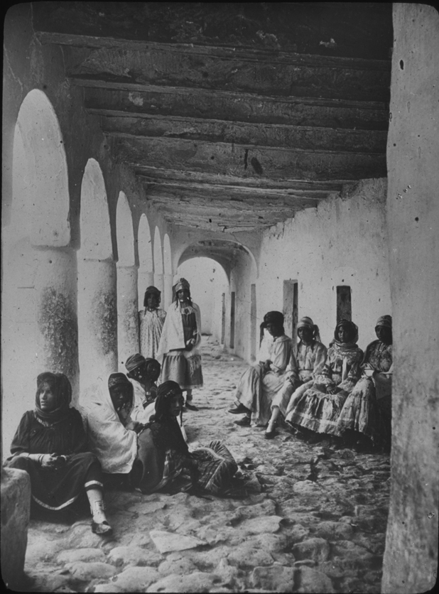 Women in Algeria sit in a covered colonnade, undated