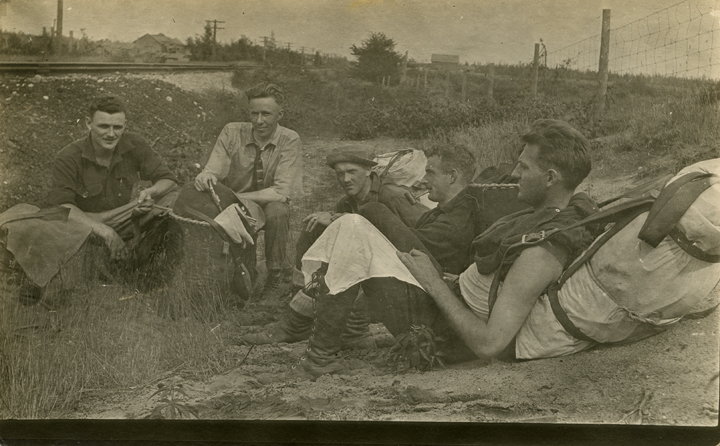 Students resting beside a railroad track, date unknown