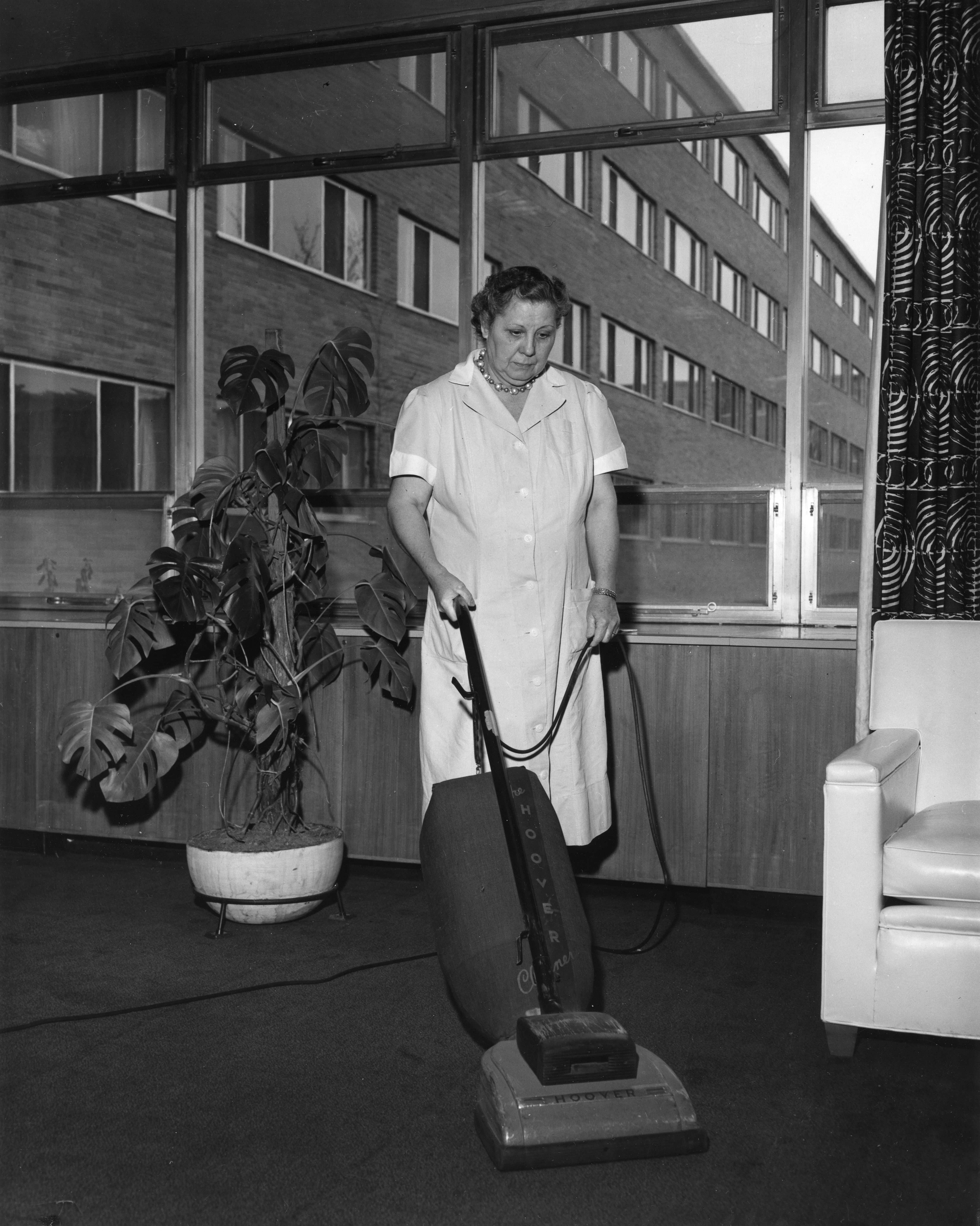 A housekeeper vacuuming, 1957