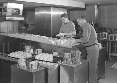 Putting away dishes in Brody Hall kitchen, 1954