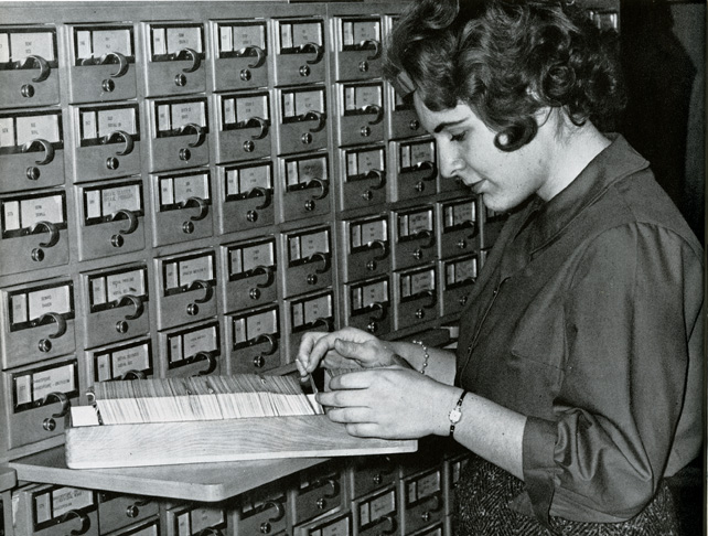Woman sorts through reference cards in the library