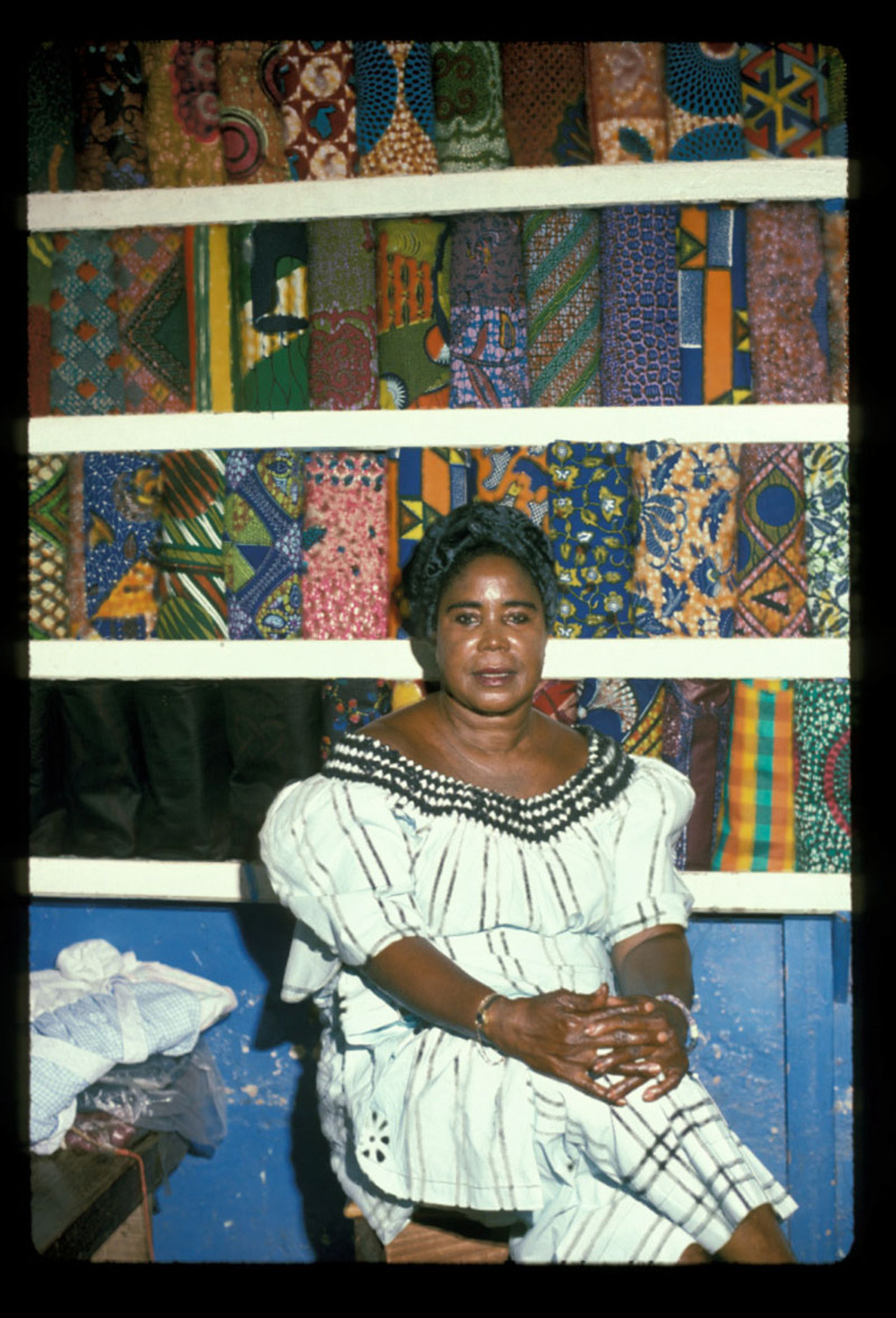 Young woman in white sitting in cloth stall